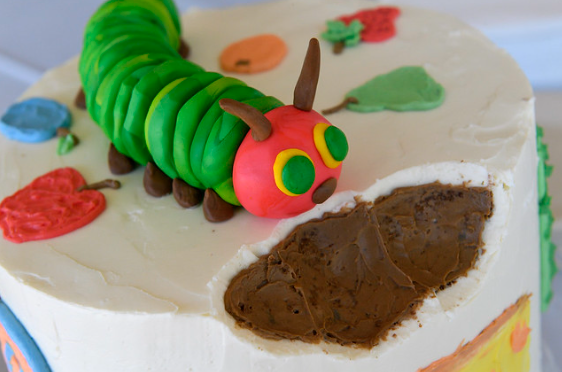A cake designed in the theme of the very hungry caterpillar.